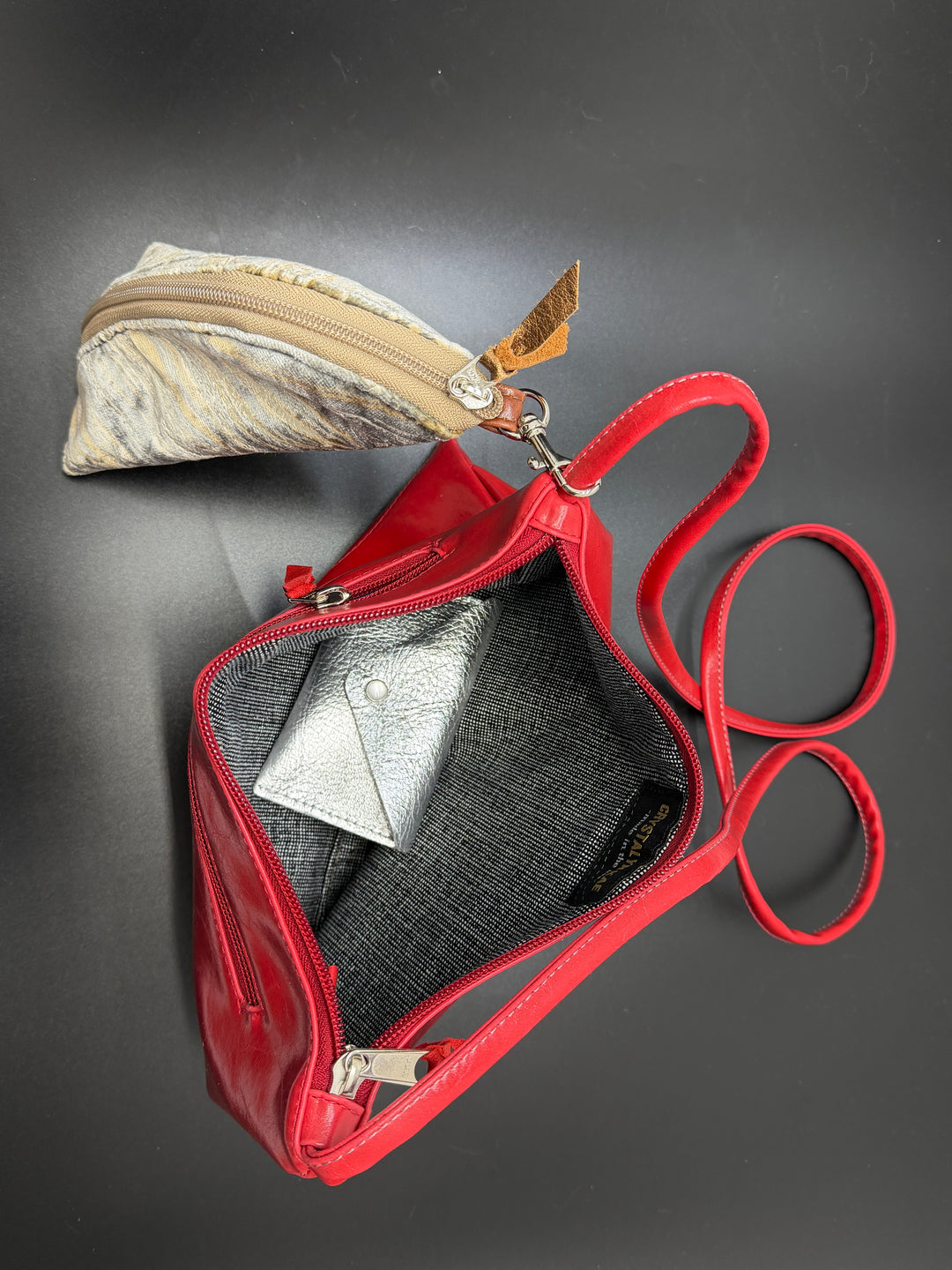 Red handbag with a visible interior on a dark background