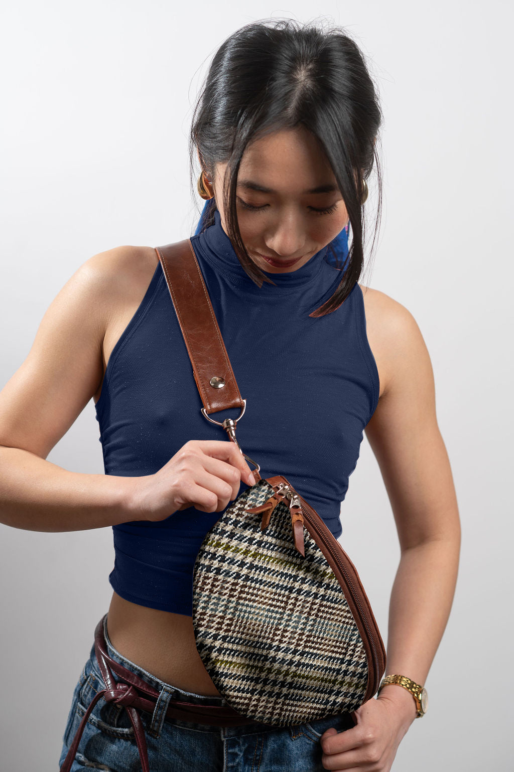 Woman holding a patterned handbag against a plain background #color_scholars-plaid