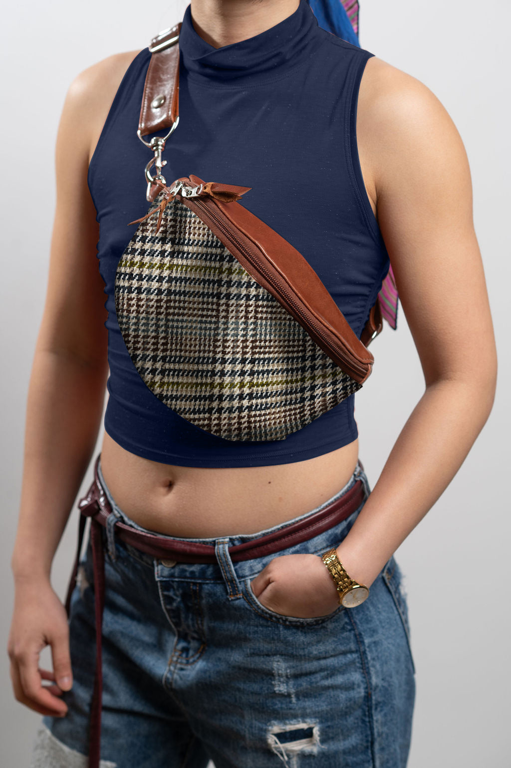 Person wearing a blue sleeveless top with a houndstooth patterned bag over their shoulder. #color_scholars-plaid