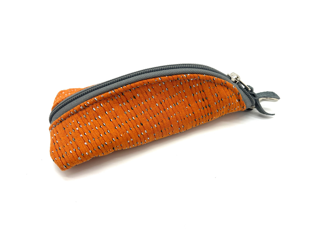 Orange textured pouch with a gray zipper on a white backgroundtangerine-takeoff