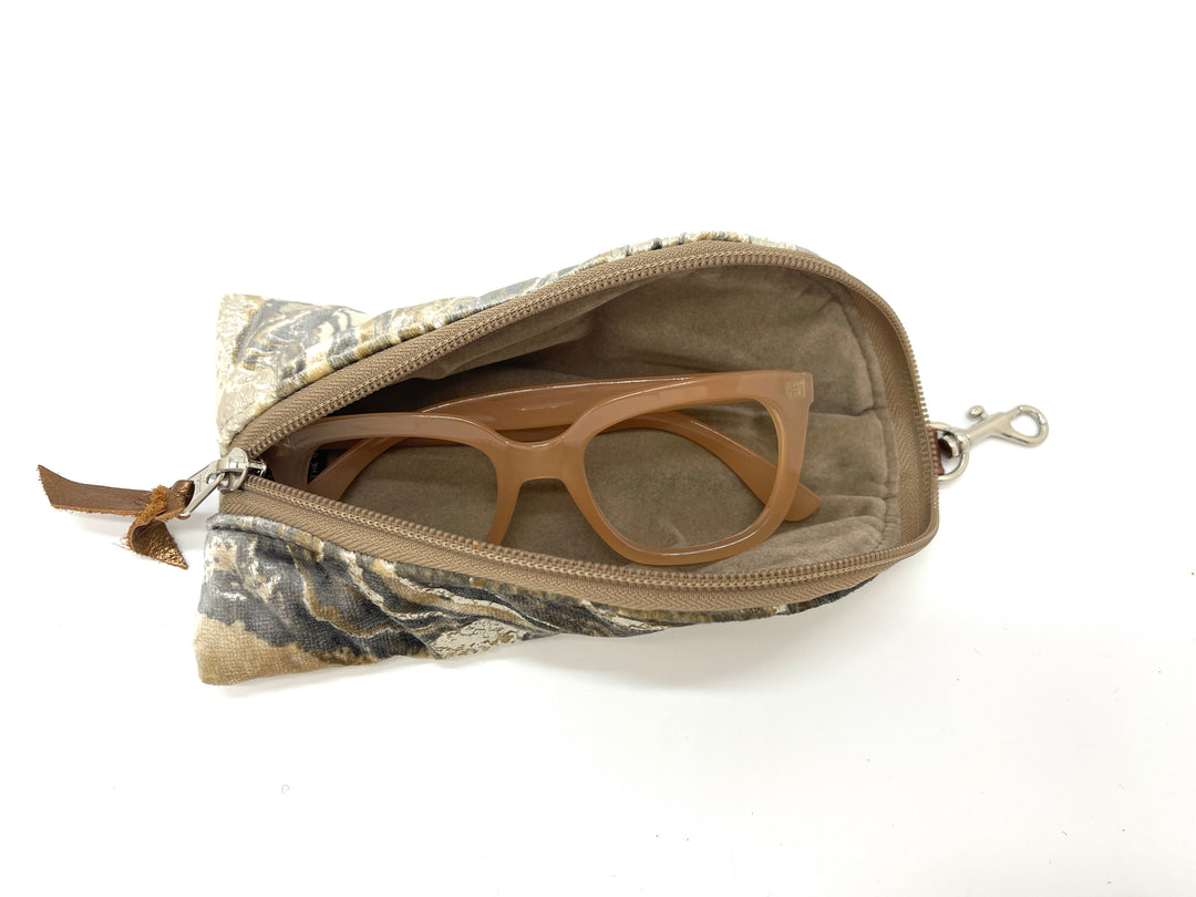 Marbled metallic velvet pouch with sunglasses on a white background#color_champagne-cosmos