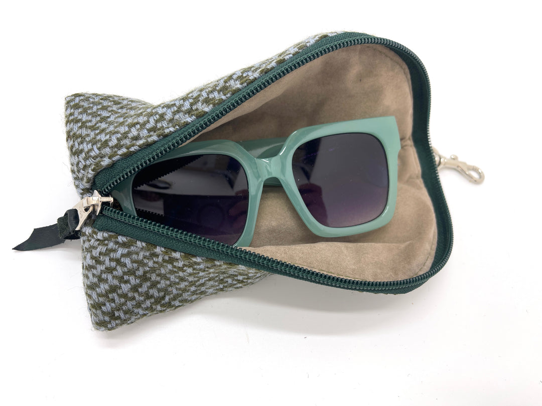 Green sunglasses in a patterned case on a white background#color_forest-tweed