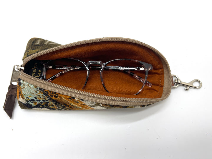 Orange floral eyeglass case with glasses inside on a white background#color_harvest-bloom