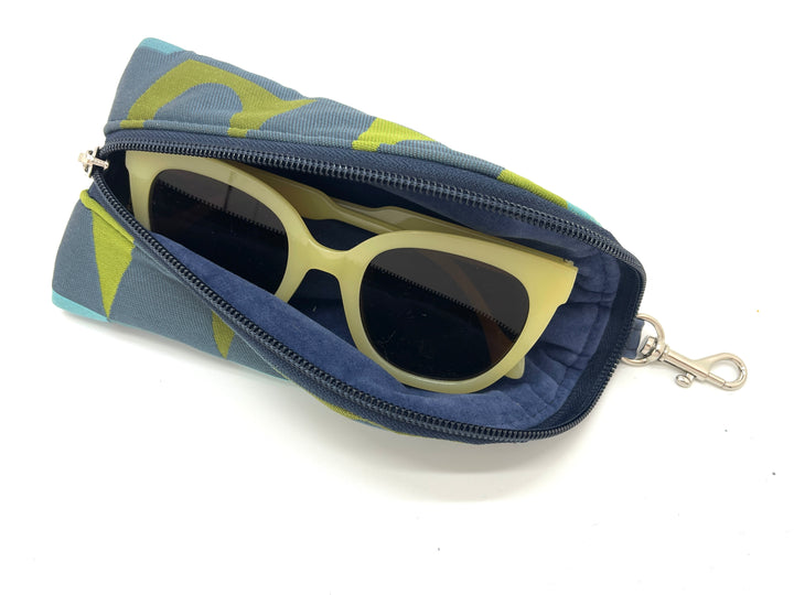 Sunglasses in a blue and green patterned case on a white background#color_satellite-sally
