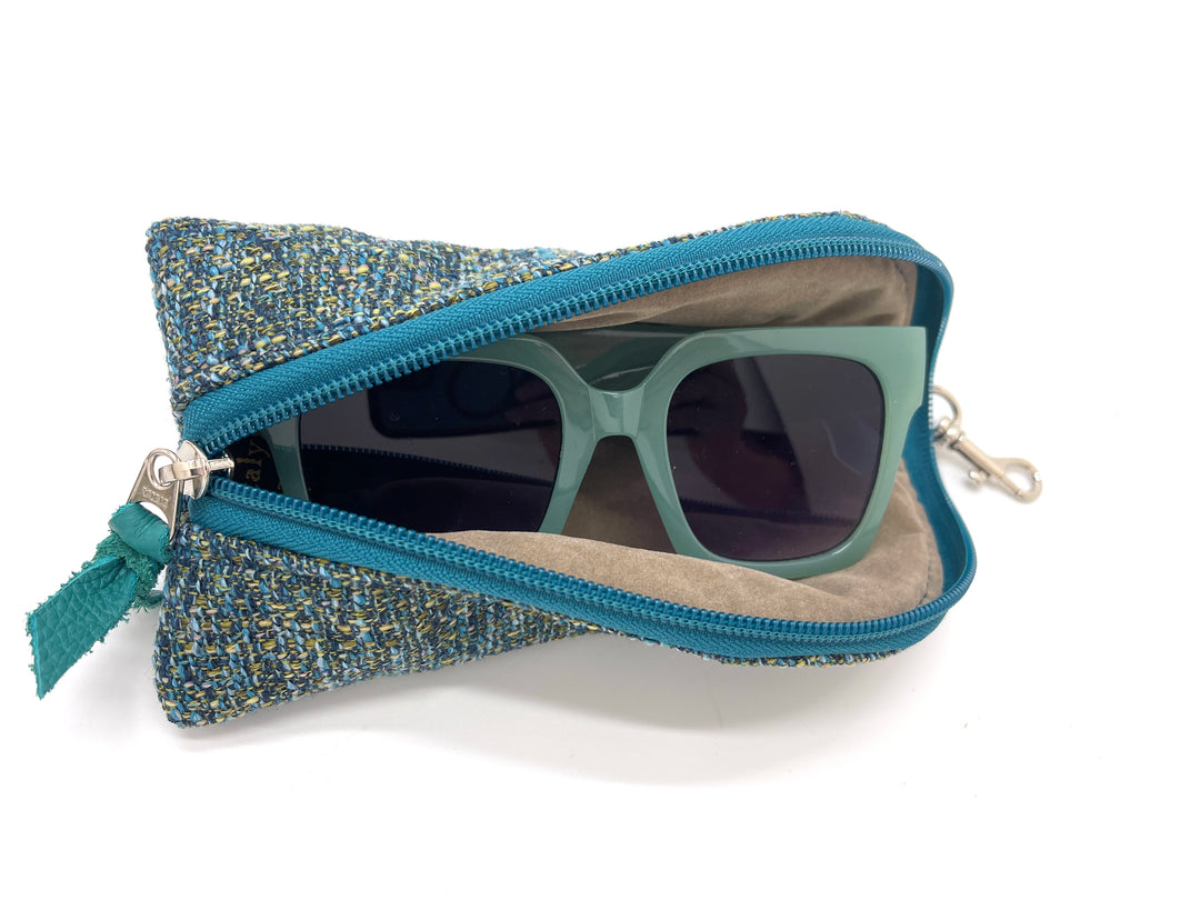 Sunglasses in a textured blue case on a white background#color_transatlantic-teal