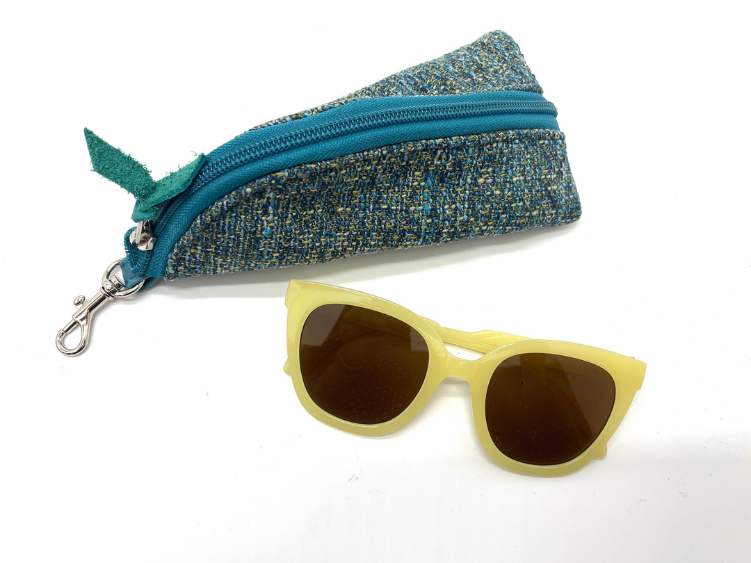 Blue textured zippered case with yellow sunglasses on a white background#color_transatlantic-teal