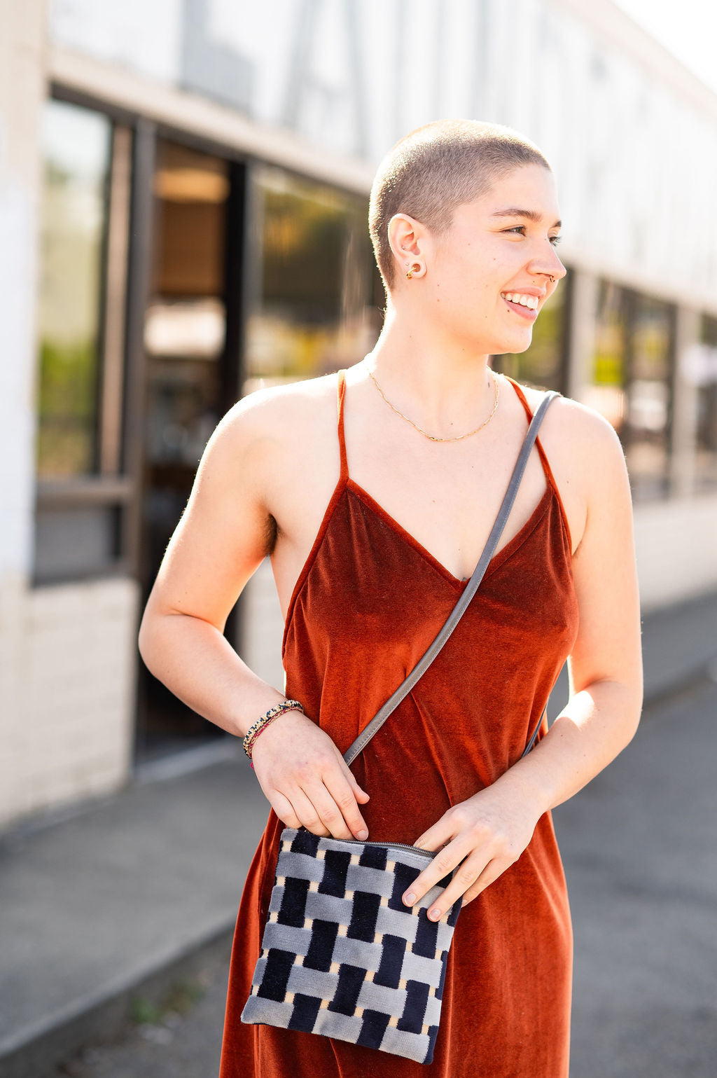 Woman in a red dress holding a patterned bag outdoors#color_navy-basketweave