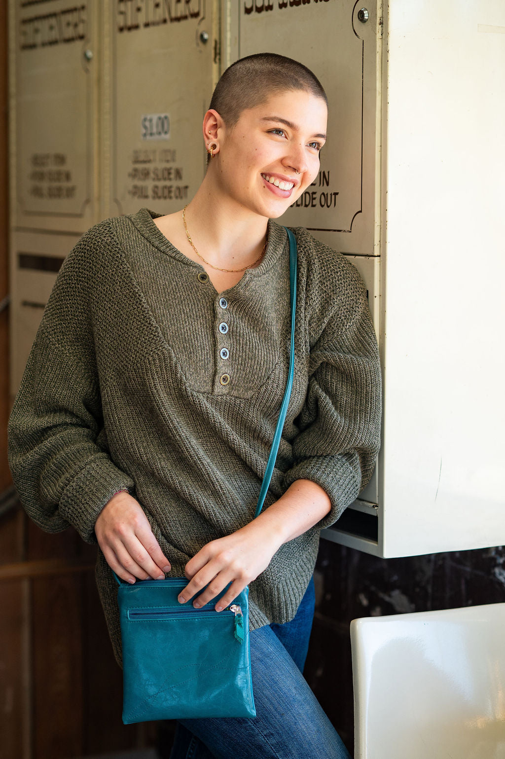 Woman holding a blue bag in an indoor setting#color_teal