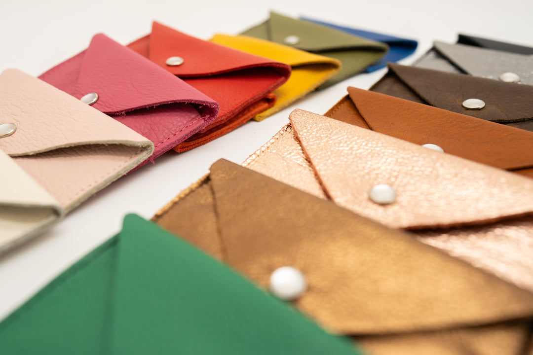 Collection of colorful leather business card case wallets on a white background