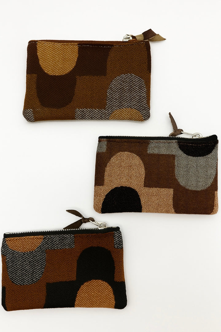 Three brown fabric pouches with abstract patterns on a white background#color_sky-arches-brown