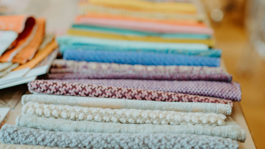 Stacked vintage fabrics in soft, rich textures—showcasing the reclaimed materials used in Crystalyn Kae bags